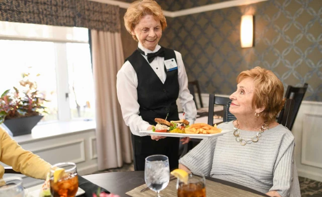 Server giving dish to resident