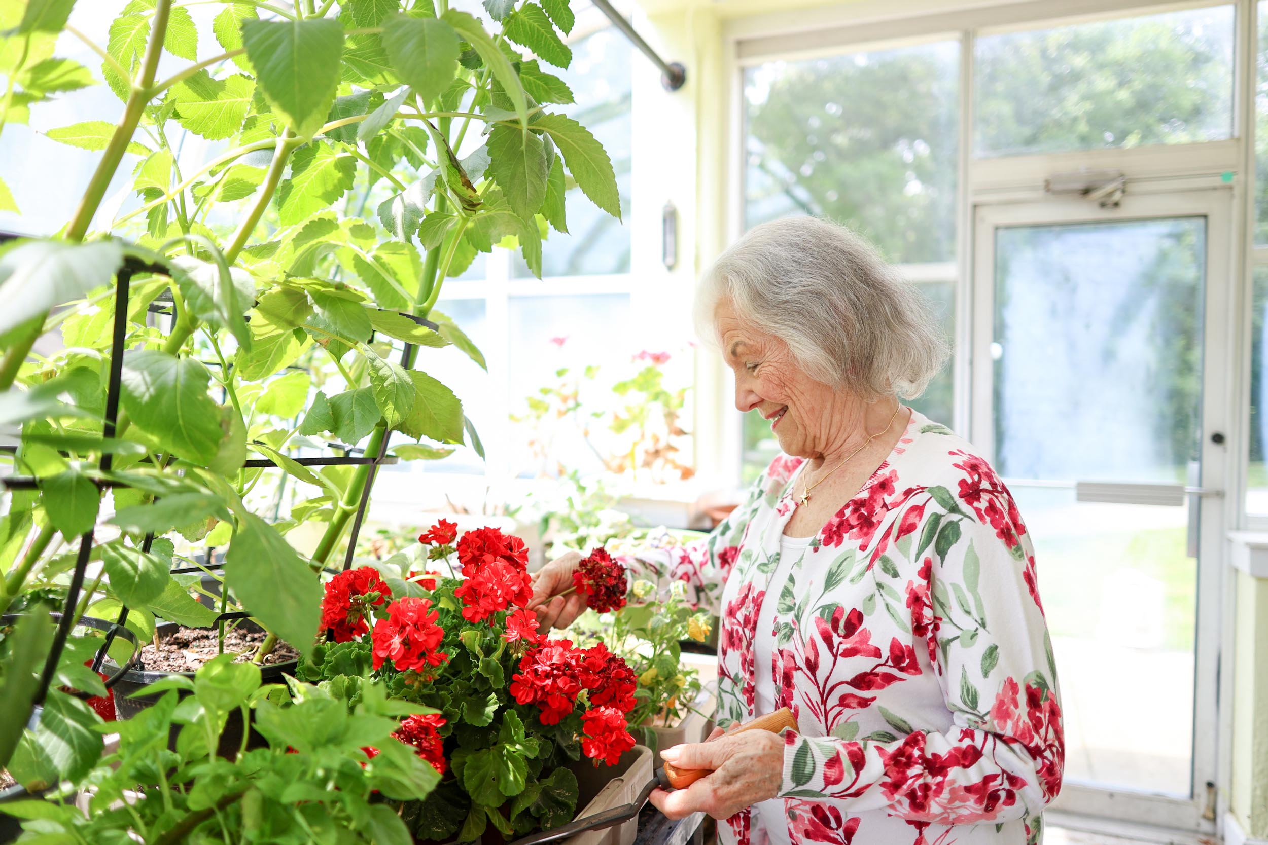 Resident Celeste gardening in the greenhouse