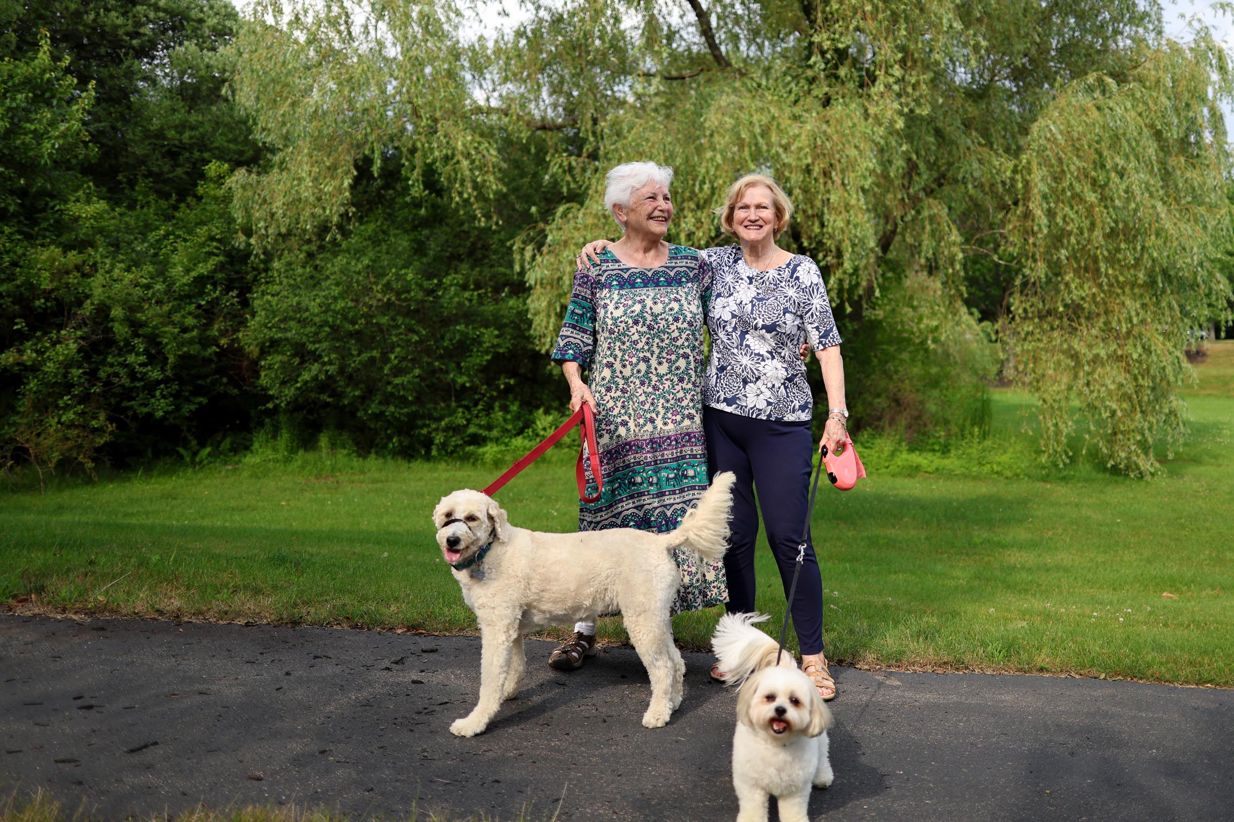 Two residents walking their dogs outside