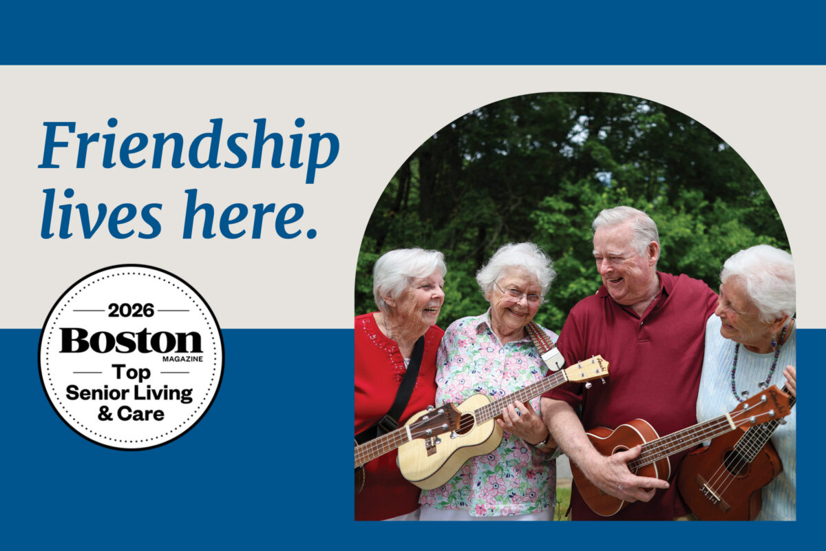 Group of four older adults smiling and playing ukuleles together outdoors, with text reading “Friendship lives here” and a Boston Magazine Top Senior Living & Care 2026 badge.