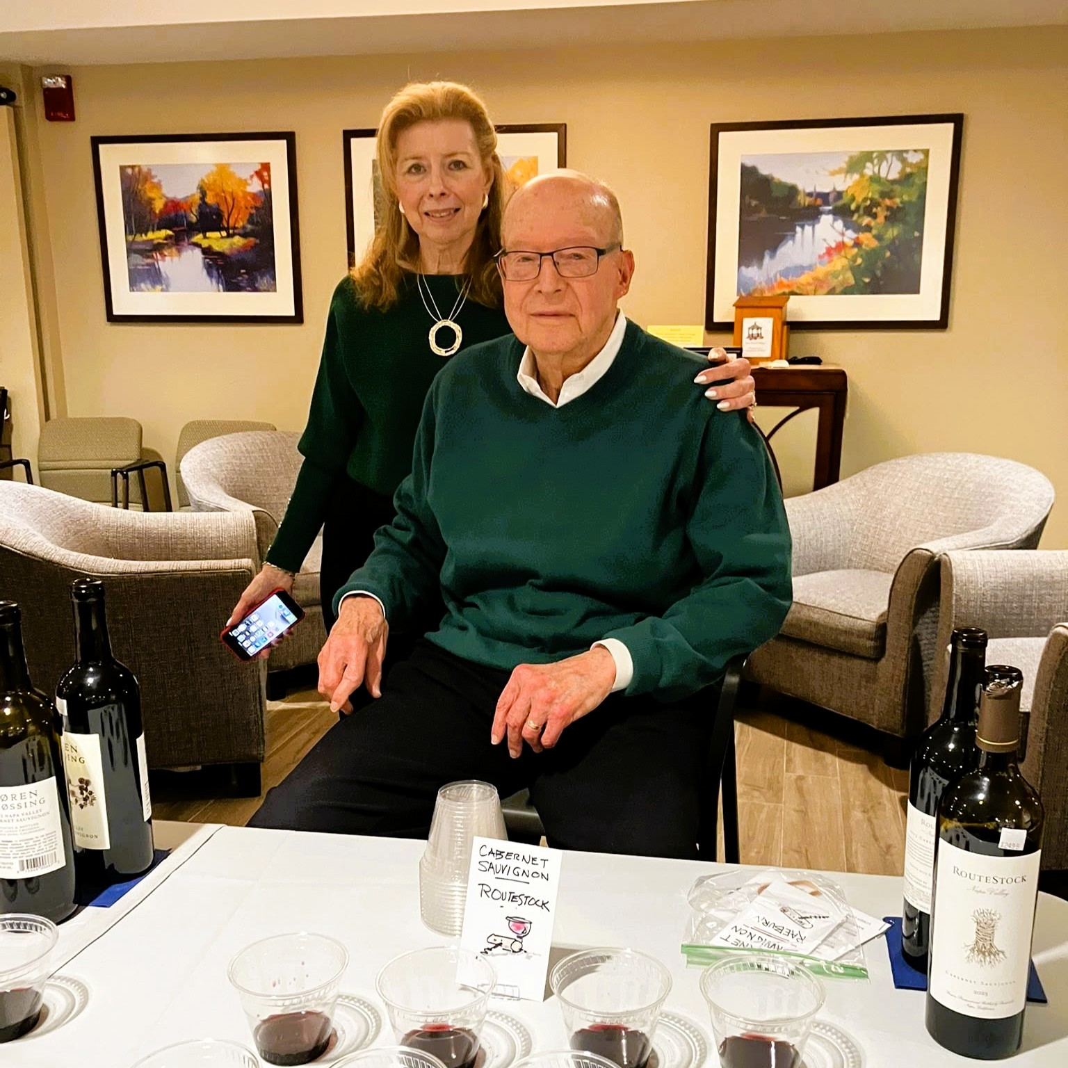 New Pond Village residents Leslie and Jerry Reicher lead a wine tasting surrounded by bottles and tasting glasses.
